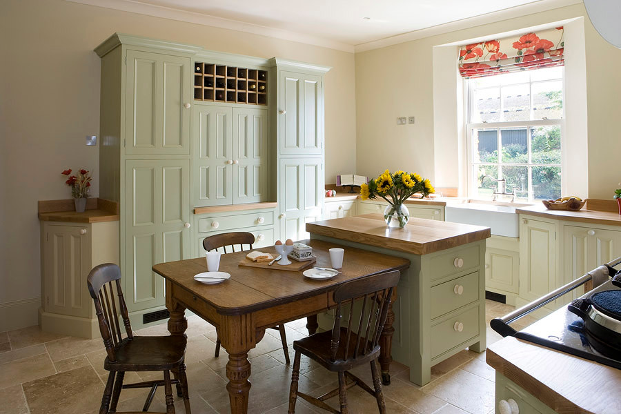 This is an example of a farmhouse kitchen in Other with beaded cabinets and wood worktops.