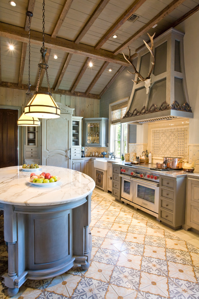 Kitchen - large traditional kitchen idea in Houston with stainless steel appliances, an island and white countertops