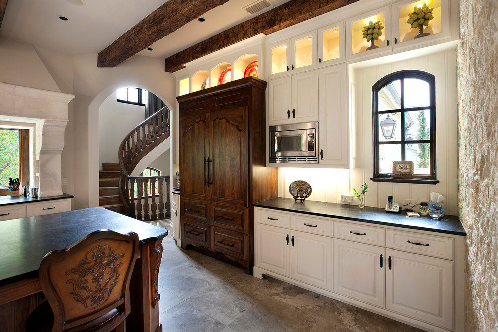 На фото: кухня в классическом стиле с фасадами с выступающей филенкой, белыми фасадами и техникой под мебельный фасад с