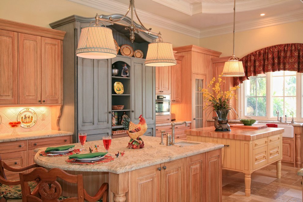 Foto di una cucina con ante con bugna sagomata e ante in legno chiaro