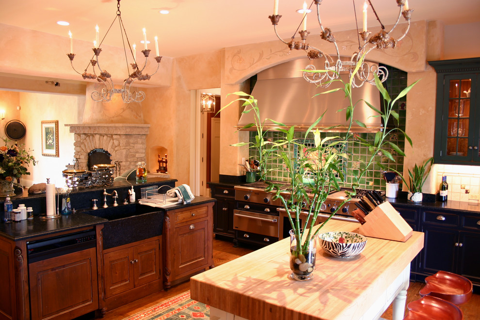 This is an example of a traditional open plan kitchen in Columbus with green splashback.
