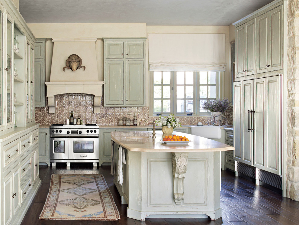 Exempel på ett avskilt u-kök, med en rustik diskho, luckor med upphöjd panel, skåp i slitet trä, brunt stänkskydd, rostfria vitvaror, mörkt trägolv, en köksö och brunt golv