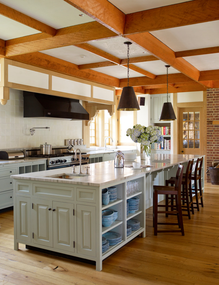 Foto di un cucina con isola centrale classico con paraspruzzi beige e pavimento in legno massello medio