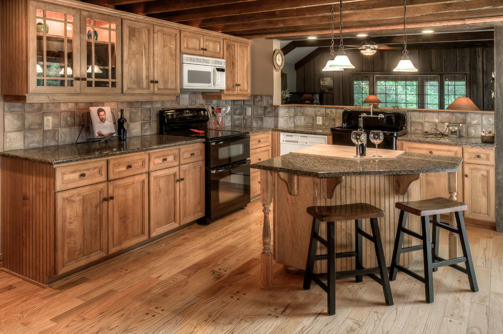 Urige Küche mit Landhausspüle, Schrankfronten mit vertiefter Füllung, hellbraunen Holzschränken, Küchenrückwand in Beige und schwarzen Elektrogeräten in Omaha