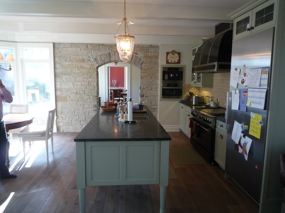 Foto di un cucina con isola centrale eclettico con pavimento in legno massello medio