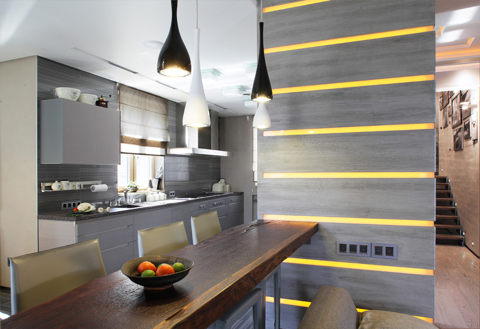Foto på ett mellanstort funkis linjärt kök och matrum, med en undermonterad diskho, släta luckor, grå skåp, grått stänkskydd, stänkskydd i keramik och ljust trägolv
