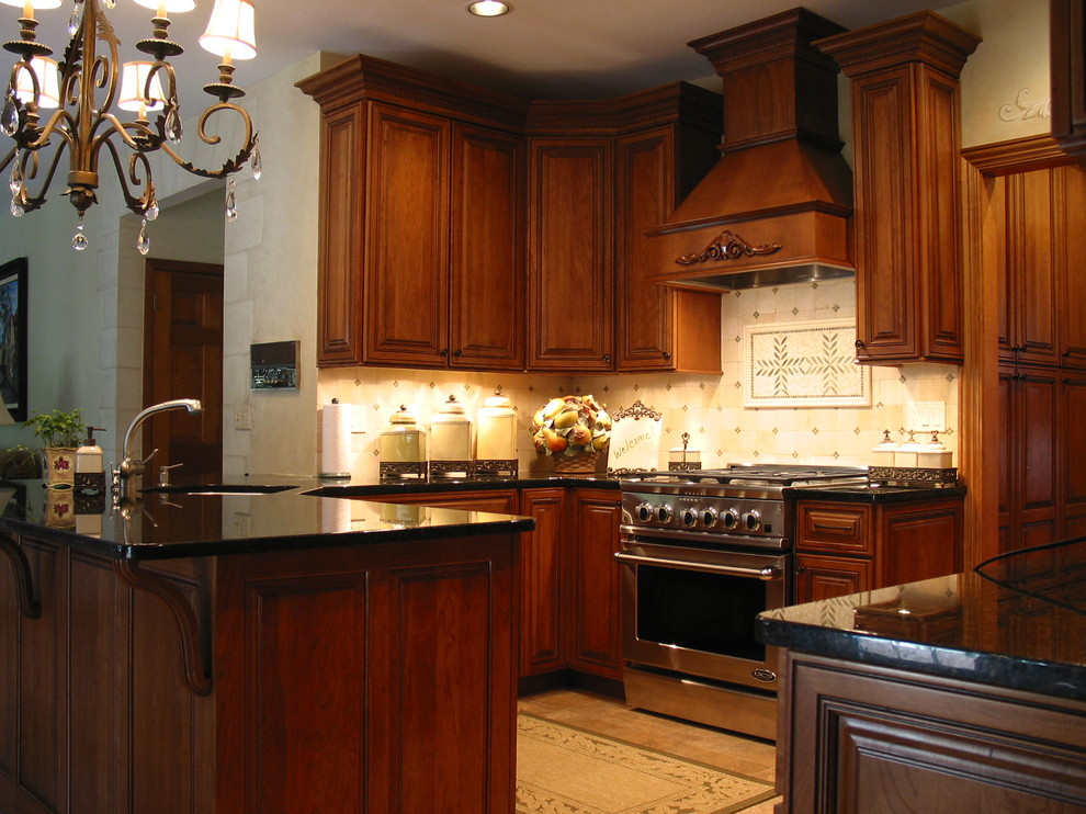 Photo of a large classic l-shaped enclosed kitchen in New York with a submerged sink, raised-panel cabinets, dark wood cabinets, granite worktops, beige splashback, stone tiled splashback, stainless steel appliances, ceramic flooring and an island.