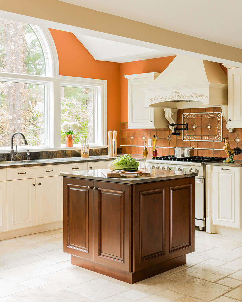 Пример оригинального дизайна: кухня в классическом стиле с фасадами с выступающей филенкой, оранжевым фартуком и техникой из нержавеющей стали
