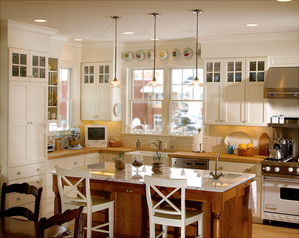Elegant kitchen photo in Minneapolis with stainless steel appliances, a farmhouse sink and wood countertops