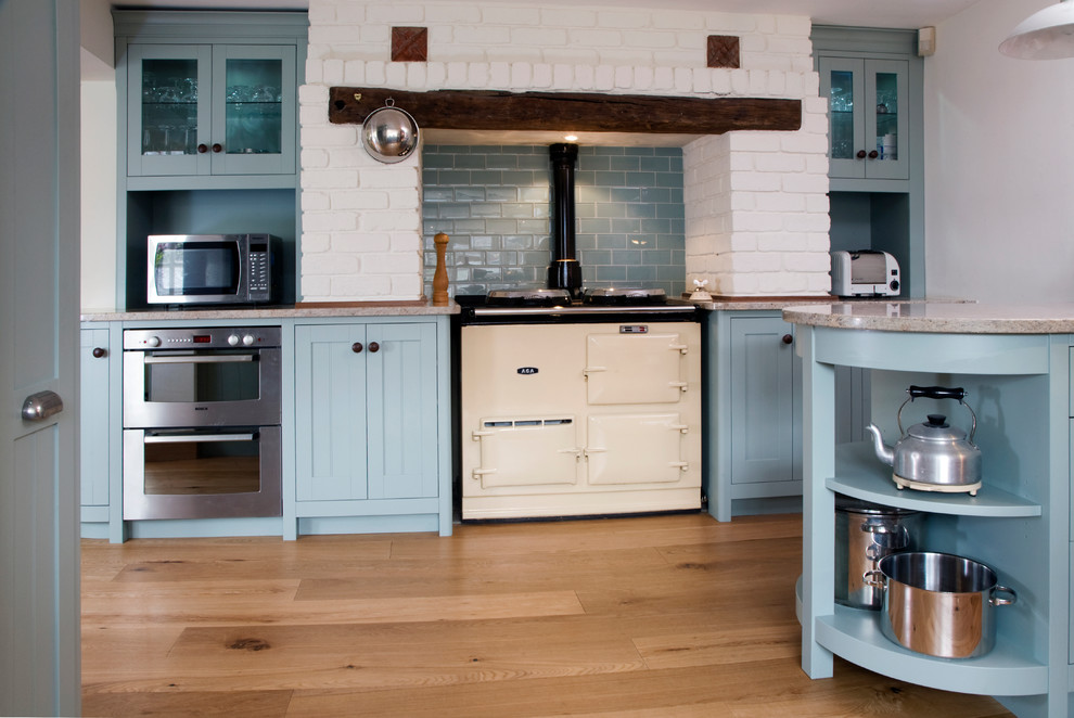 Diseño de cocina tradicional con salpicadero azul, salpicadero de azulejos tipo metro y electrodomésticos blancos