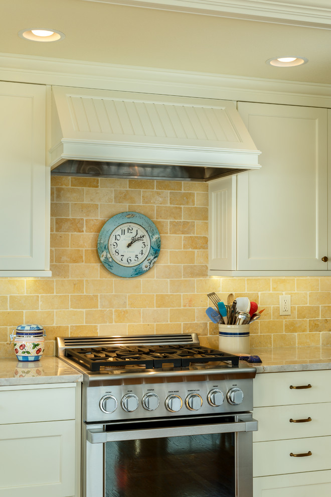Bild på ett stort vintage kök, med en rustik diskho, luckor med infälld panel, vita skåp, granitbänkskiva, gult stänkskydd, rostfria vitvaror, mellanmörkt trägolv och stänkskydd i stenkakel