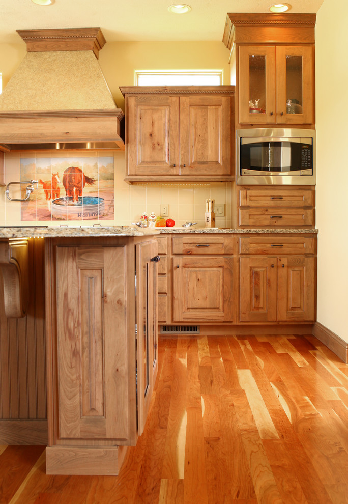 Foto di una cucina country con ante con bugna sagomata e ante in legno chiaro