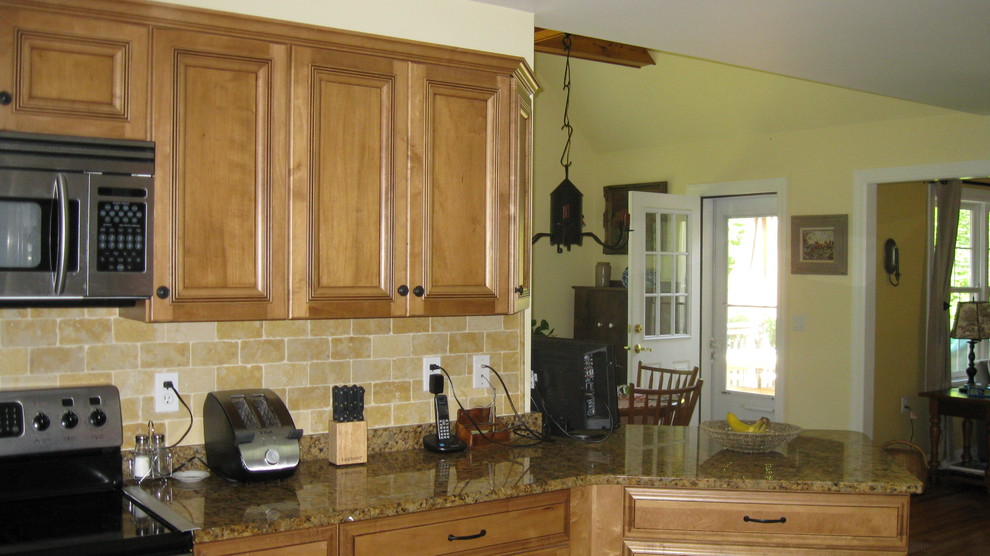 Foto på ett mellanstort lantligt kök, med en undermonterad diskho, luckor med infälld panel, granitbänkskiva, beige stänkskydd, rostfria vitvaror, skåp i ljust trä, stänkskydd i stenkakel och klinkergolv i porslin