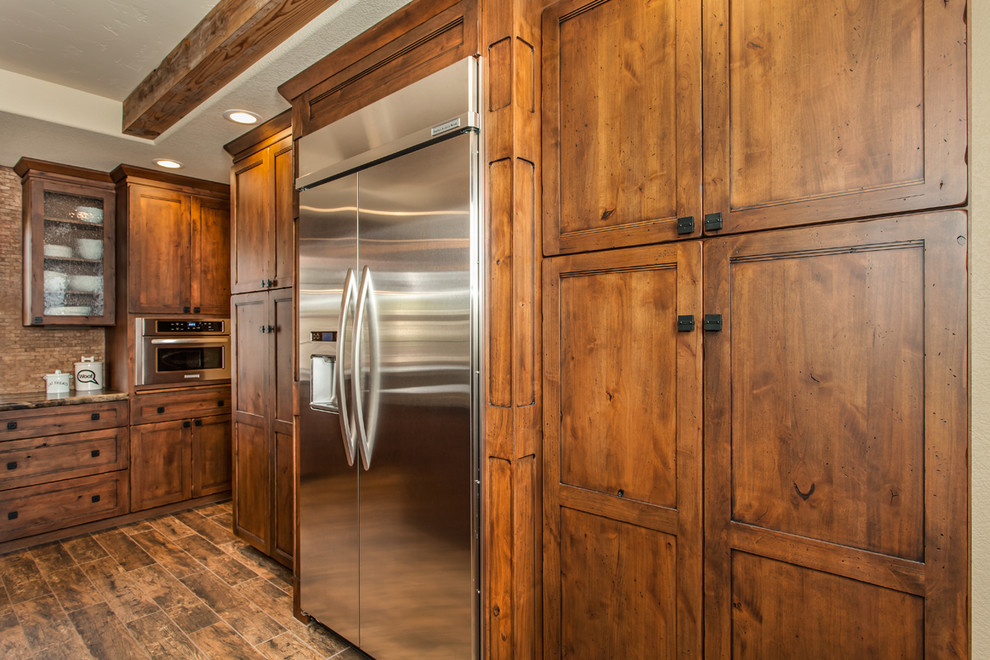This is an example of a large rural l-shaped kitchen/diner in Sacramento with a submerged sink, shaker cabinets, medium wood cabinets, granite worktops, beige splashback, stainless steel appliances, medium hardwood flooring and an island.