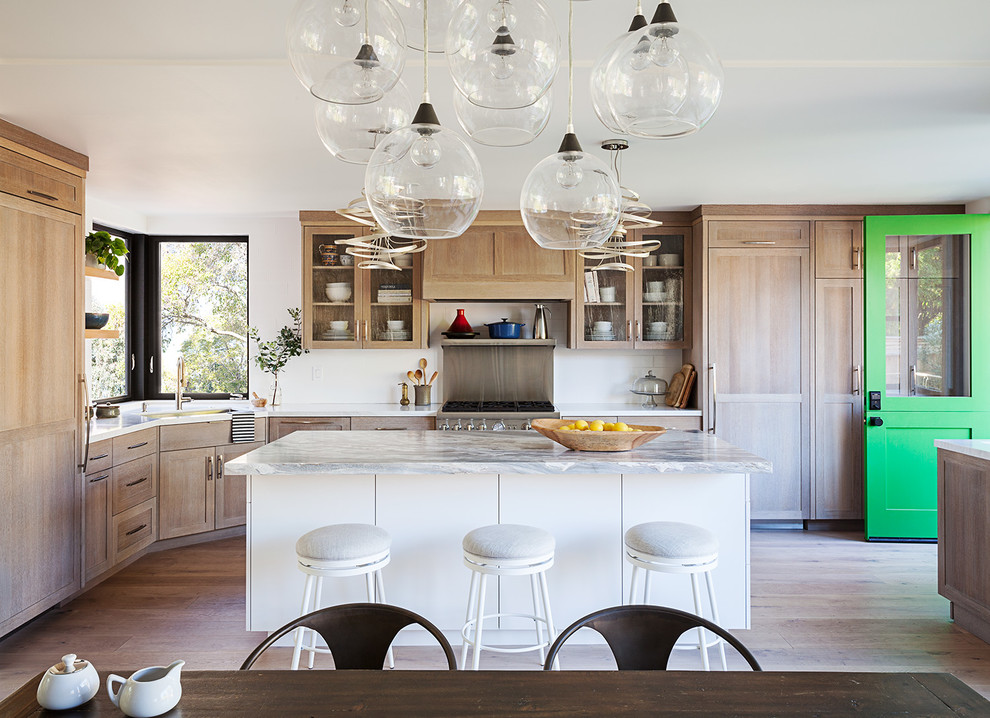 Foto di una cucina chic con lavello sottopiano, ante in stile shaker, ante in legno chiaro, elettrodomestici da incasso e parquet chiaro