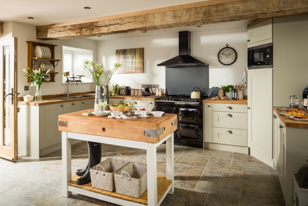 Inspiration for a medium sized farmhouse u-shaped kitchen in Other with shaker cabinets, wood worktops, black appliances, limestone flooring, an island, a double-bowl sink and black splashback.