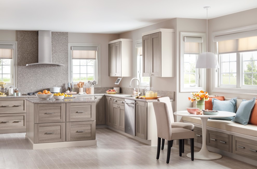 Eat-in kitchen - mid-sized transitional u-shaped light wood floor eat-in kitchen idea in New York with shaker cabinets, medium tone wood cabinets, quartz countertops, gray backsplash, stainless steel appliances and an island
