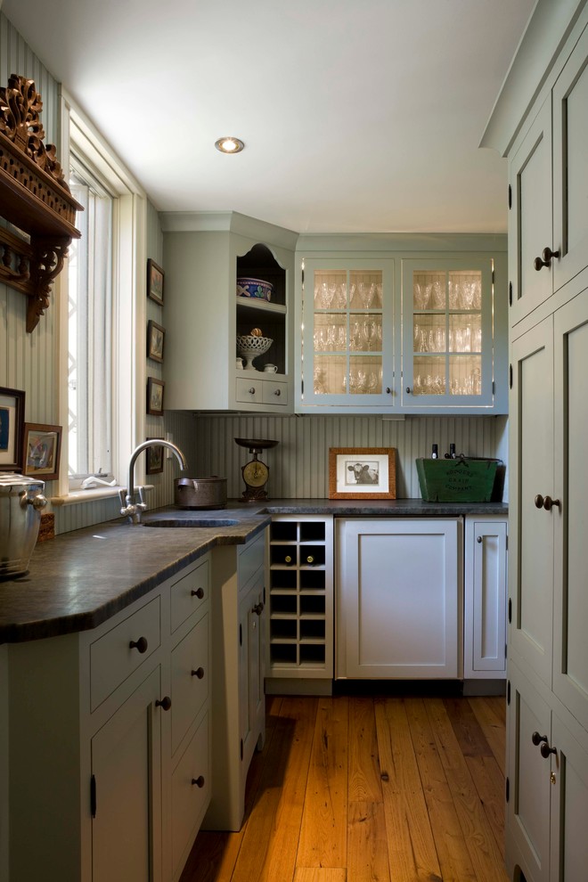 На фото: отдельная, угловая кухня в классическом стиле с монолитной мойкой, фасадами в стиле шейкер, зелеными фасадами, гранитной столешницей и зеленым фартуком