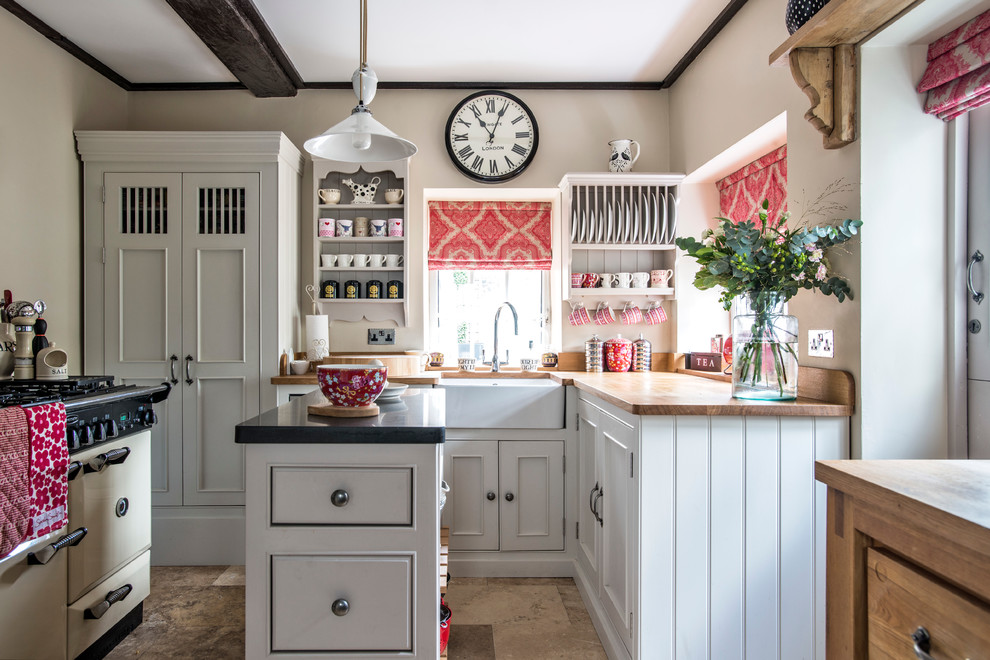Foto de cocinas en L estrecha, de estilo de casa de campo, con fregadero sobremueble, armarios con rebordes decorativos, puertas de armario blancas, encimera de madera y una isla