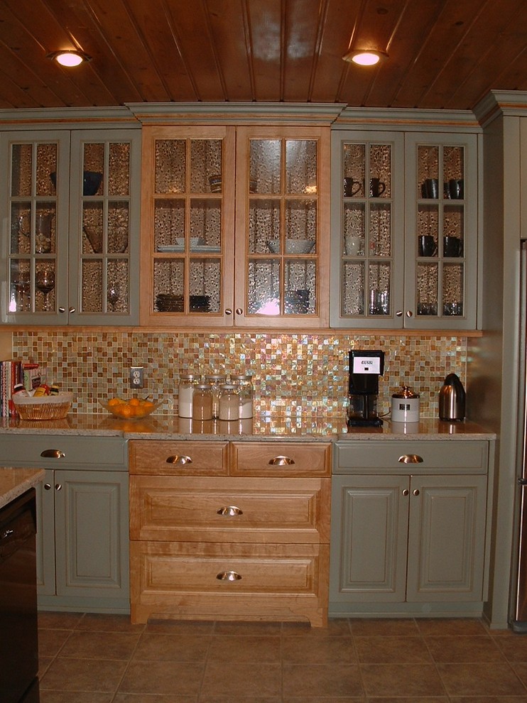 Foto di una cucina stile rurale con lavello sottopiano, ante con bugna sagomata, ante verdi, top in quarzo composito, paraspruzzi multicolore e elettrodomestici neri