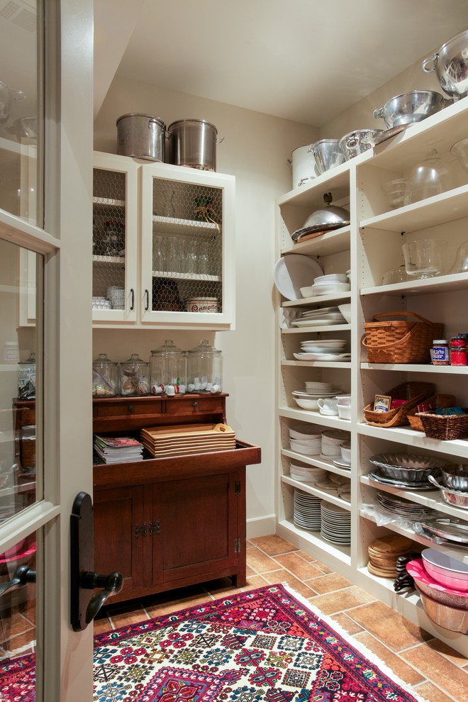 Farmhouse kitchen pantry in Austin with terracotta flooring.