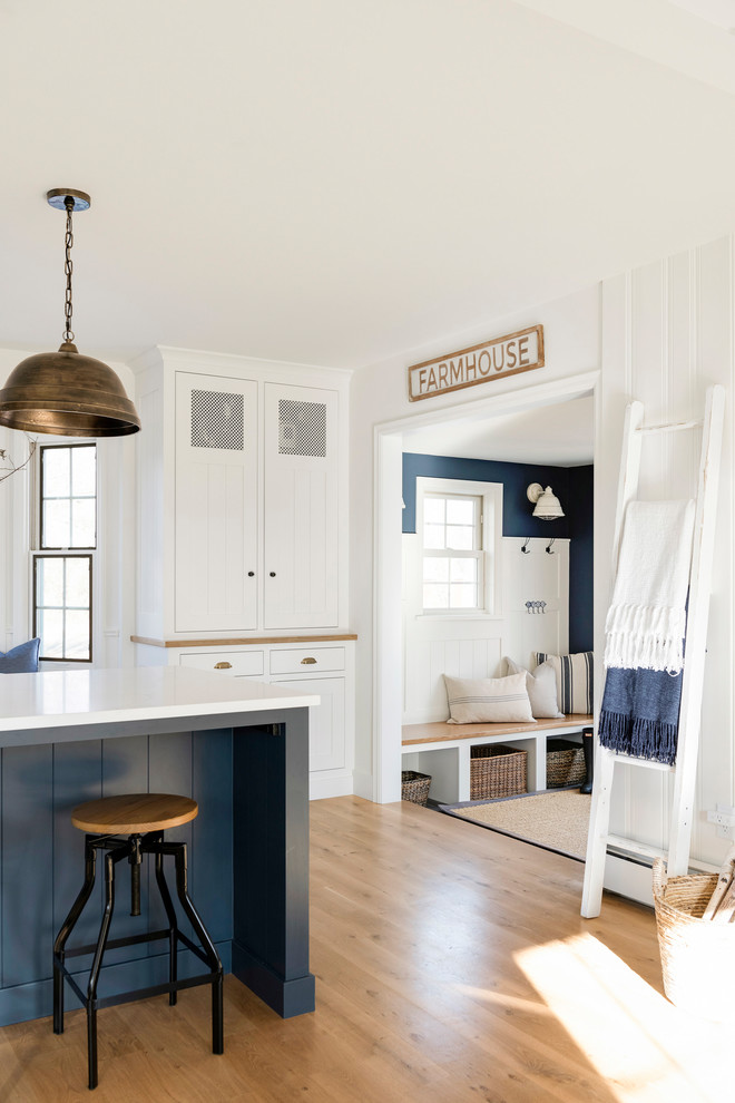 Eat-in kitchen - country light wood floor and beige floor eat-in kitchen idea in Minneapolis with a farmhouse sink, white cabinets, brick backsplash, stainless steel appliances, an island and white countertops