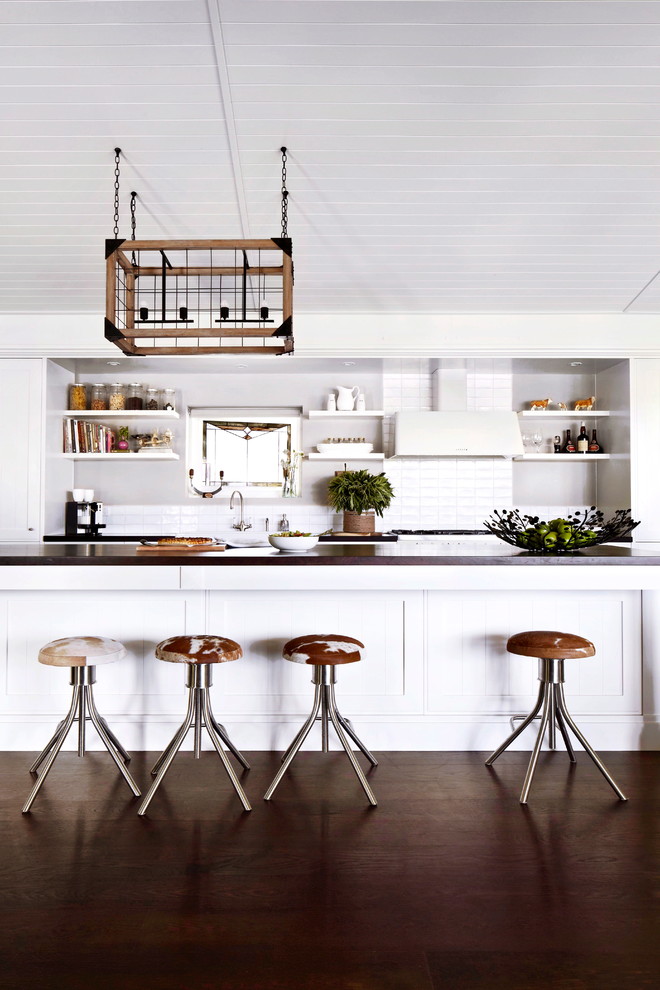 Inspiration for a large country galley dark wood floor open concept kitchen remodel in Melbourne with a farmhouse sink, shaker cabinets, white cabinets, wood countertops, white backsplash, ceramic backsplash, white appliances, an island and gray countertops