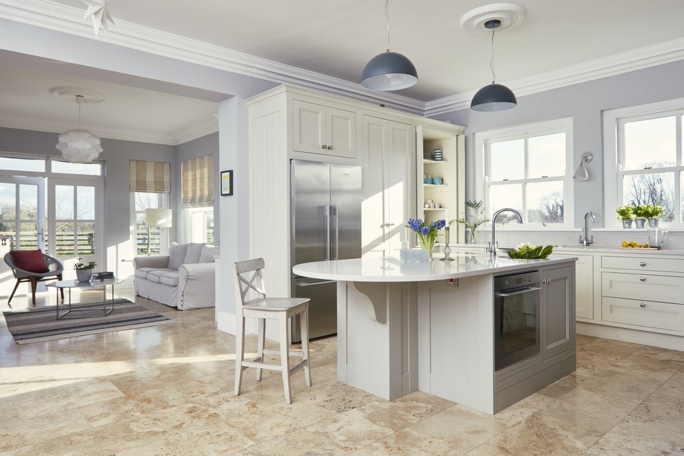 Foto på ett mellanstort lantligt vit kök, med luckor med infälld panel, grå skåp, bänkskiva i kvartsit, rostfria vitvaror, en köksö och beiget golv