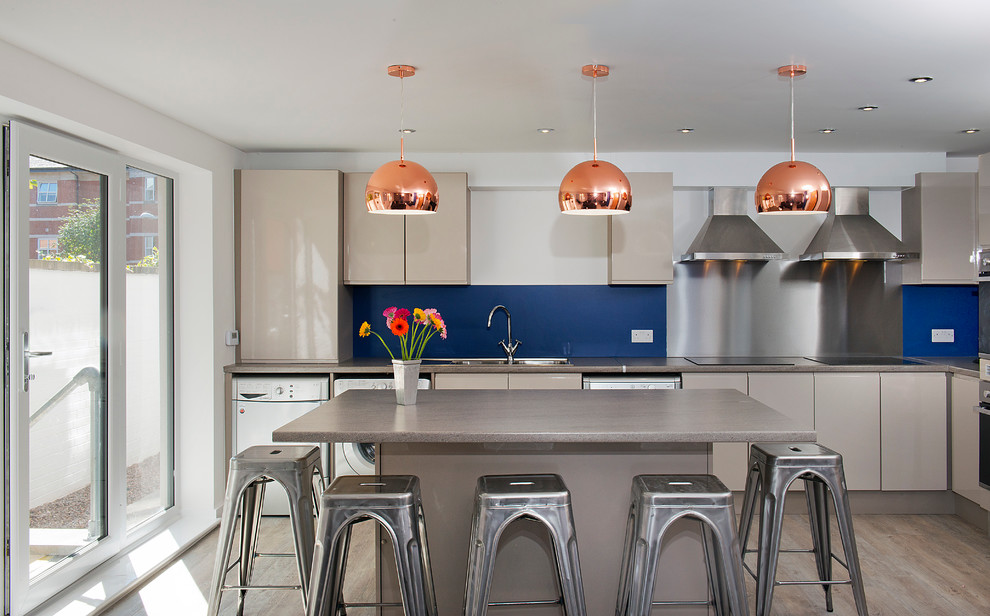 Moderne Wohnküche in L-Form mit flächenbündigen Schrankfronten, beigen Schränken, Laminat-Arbeitsplatte, Küchenrückwand in Blau, Vinylboden und Kücheninsel in West Midlands