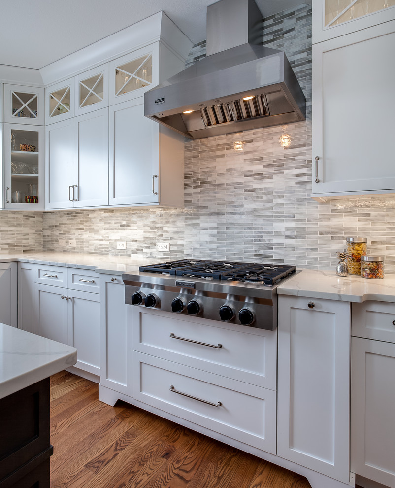 Inspiration for a mid-sized transitional u-shaped medium tone wood floor and brown floor eat-in kitchen remodel in Denver with an undermount sink, shaker cabinets, white cabinets, quartzite countertops, multicolored backsplash, stainless steel appliances, an island, matchstick tile backsplash and white countertops
