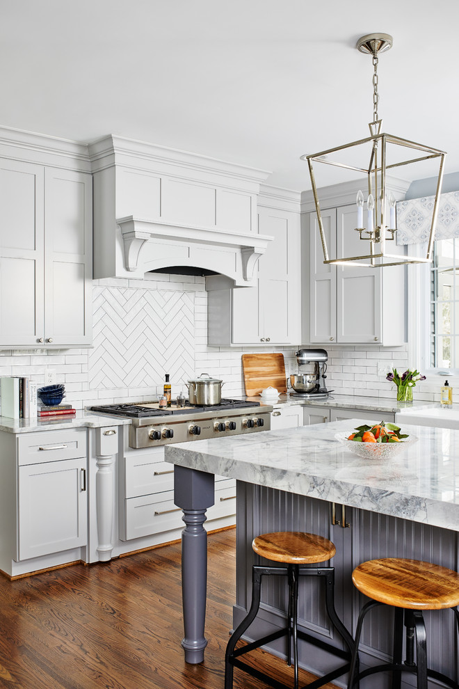 Large transitional l-shaped medium tone wood floor and brown floor eat-in kitchen photo in Chicago with a farmhouse sink, shaker cabinets, gray cabinets, quartzite countertops, gray backsplash, porcelain backsplash, stainless steel appliances, an island and gray countertops