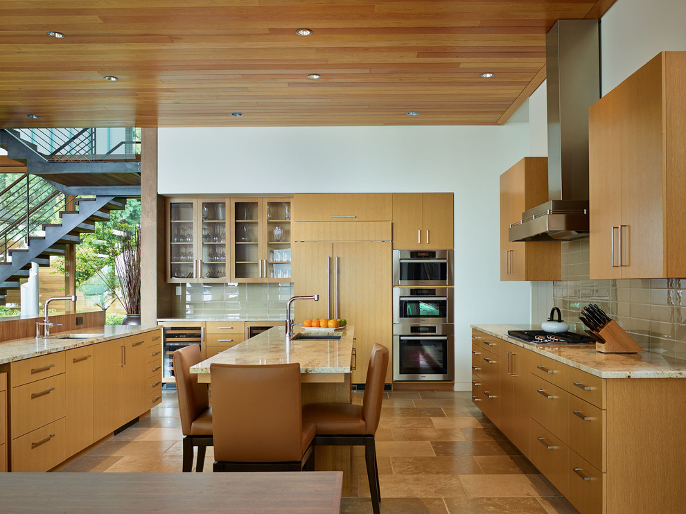 Moderne Küche mit flächenbündigen Schrankfronten, Granit-Arbeitsplatte und Elektrogeräten mit Frontblende in Seattle