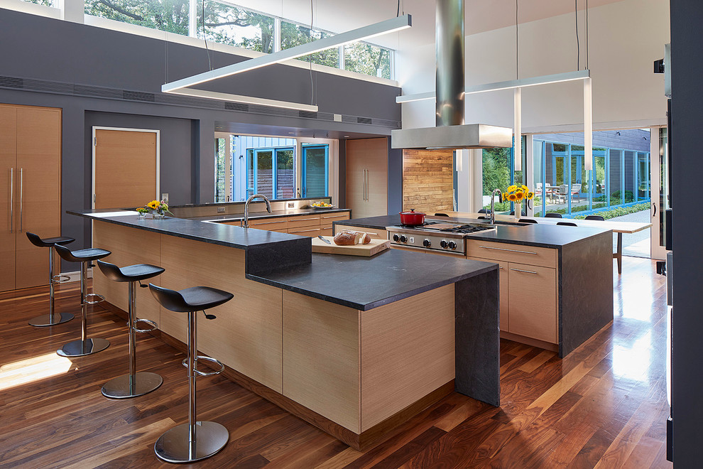 Large contemporary kitchen/diner in Chicago with flat-panel cabinets, light wood cabinets, granite worktops, multiple islands, window splashback, stainless steel appliances and medium hardwood flooring.