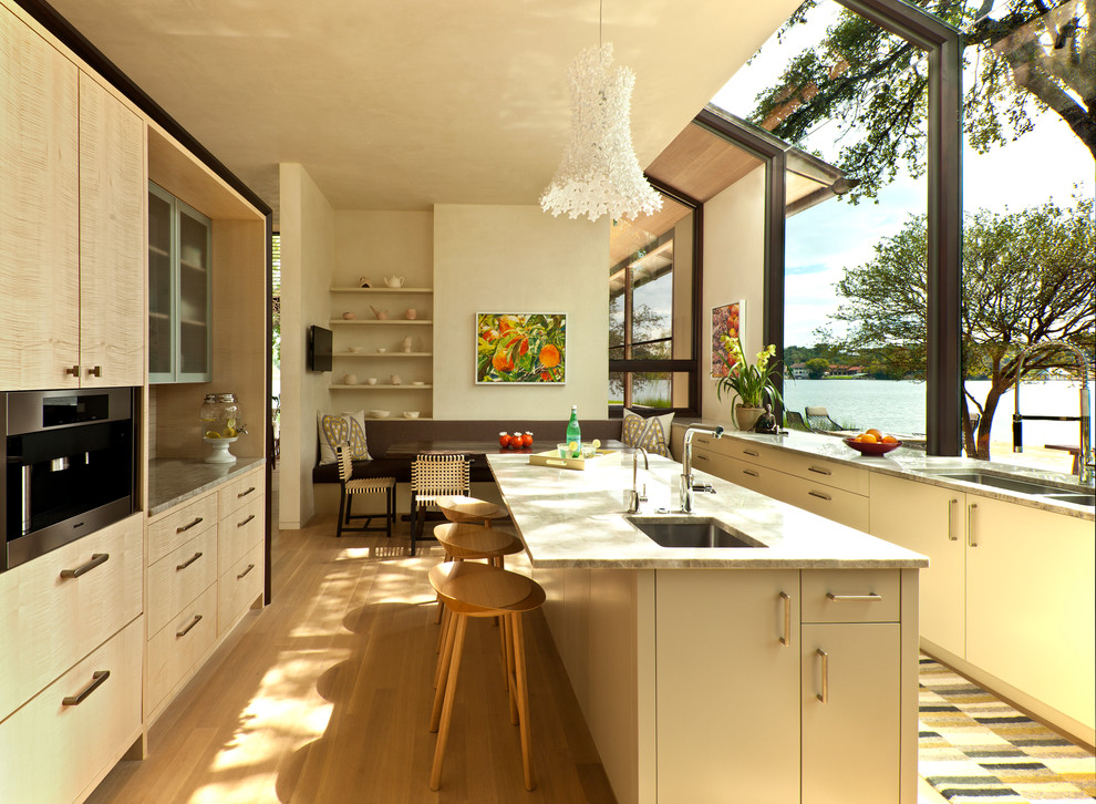 Ejemplo de cocina comedor minimalista con fregadero bajoencimera, armarios con paneles lisos y puertas de armario de madera clara