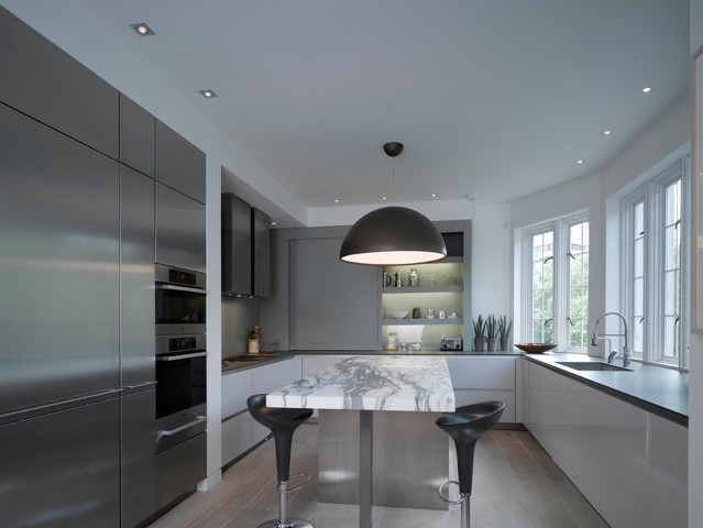 Inspiration for a large contemporary u-shaped kitchen/diner in Other with a submerged sink, flat-panel cabinets, white cabinets, marble worktops, stainless steel appliances, light hardwood flooring and an island.