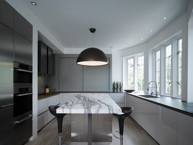 This is an example of a large contemporary u-shaped kitchen/diner in London with a submerged sink, flat-panel cabinets, white cabinets, marble worktops, stainless steel appliances, light hardwood flooring and an island.