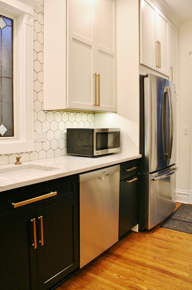 Klassisk inredning av ett litet kök, med en undermonterad diskho, skåp i shakerstil, vita skåp, bänkskiva i kvarts, vitt stänkskydd, stänkskydd i porslinskakel, rostfria vitvaror, mellanmörkt trägolv, en köksö och brunt golv