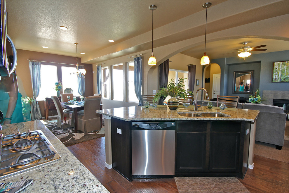 Exemple d'une cuisine ouverte chic en L de taille moyenne avec un placard à porte shaker, des portes de placard noires, un plan de travail en granite, un sol en bois brun et îlot.