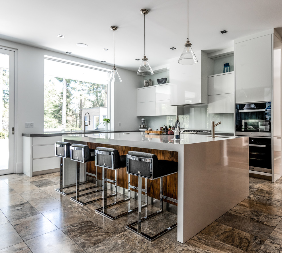 Inspiration for a contemporary l-shaped kitchen in Toronto with a submerged sink, flat-panel cabinets, white cabinets, white splashback, glass sheet splashback, black appliances, an island, brown floors and white worktops.