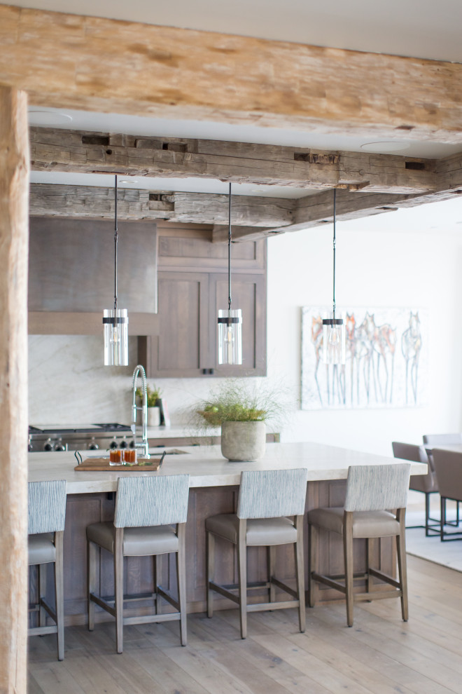 Rustic l-shaped open plan kitchen in Jackson with quartz worktops, beige splashback, stone slab splashback, light hardwood flooring, an island and beige worktops.