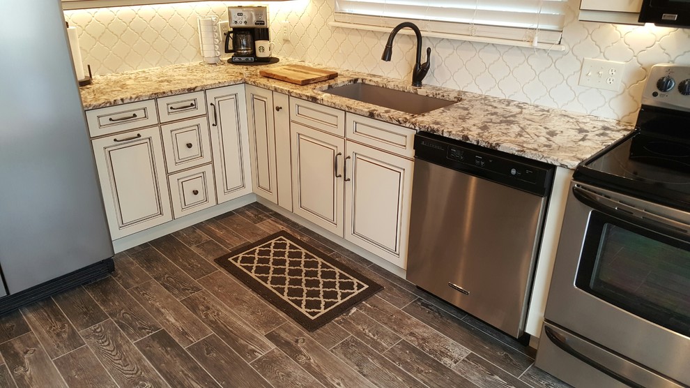 Mid-sized elegant u-shaped plywood floor eat-in kitchen photo in Denver with a double-bowl sink, recessed-panel cabinets, white cabinets, granite countertops, multicolored backsplash, ceramic backsplash, stainless steel appliances and an island