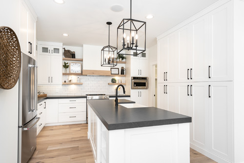 Black Countertop and Subway Backsplash in a Farmhouse White Cabinets with Wooden Shelves