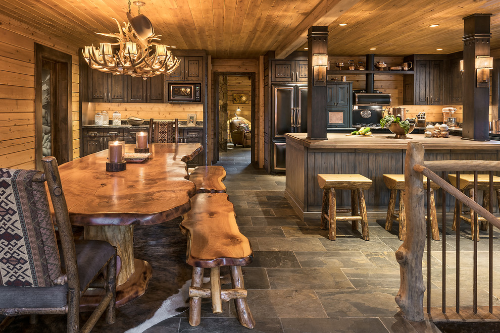Inspiration for a small rustic l-shaped slate floor and gray floor eat-in kitchen remodel in Phoenix with a farmhouse sink, distressed cabinets, granite countertops, brown backsplash and black appliances