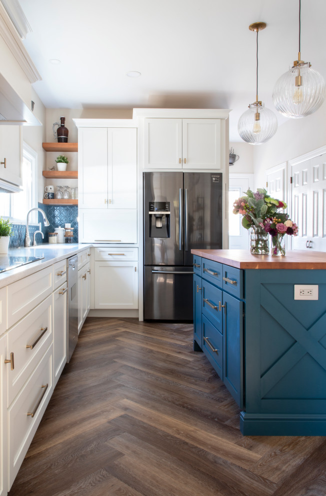 Foto på ett vintage vit kök, med en undermonterad diskho, skåp i shakerstil, blå skåp, bänkskiva i kvarts, blått stänkskydd, stänkskydd i keramik, svarta vitvaror, vinylgolv och en köksö