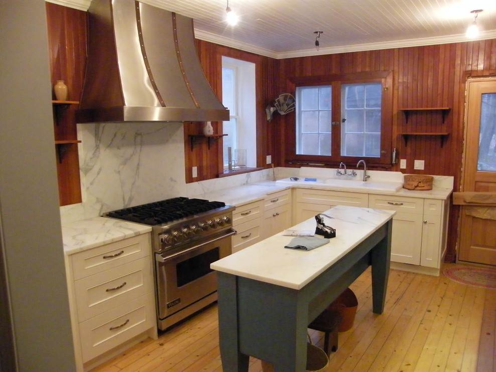 Example of a mid-sized mountain style l-shaped light wood floor eat-in kitchen design in Toronto with a double-bowl sink, raised-panel cabinets, white cabinets, wood countertops, gray backsplash, stone slab backsplash, stainless steel appliances and an island