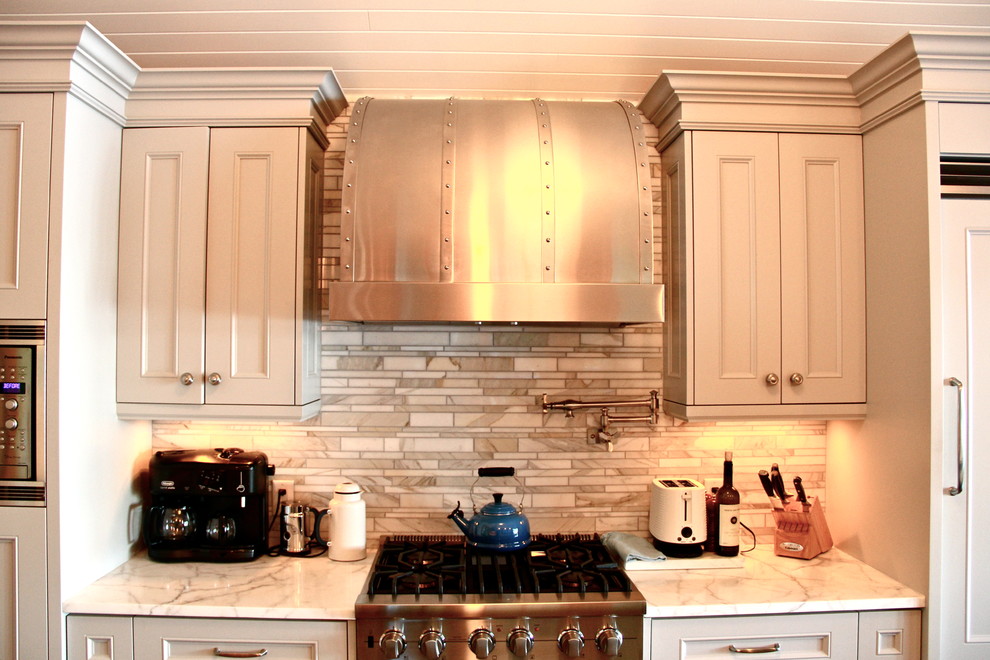 Inredning av ett rustikt stort kök, med en nedsänkt diskho, luckor med upphöjd panel, vita skåp, bänkskiva i täljsten, grått stänkskydd, stänkskydd i stickkakel, rostfria vitvaror, mörkt trägolv och en köksö