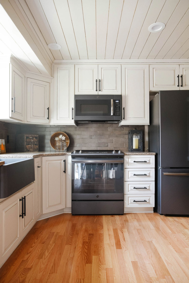 Exempel på ett avskilt, mellanstort lantligt flerfärgad flerfärgat l-kök, med en rustik diskho, luckor med upphöjd panel, vita skåp, bänkskiva i kvarts, beige stänkskydd, stänkskydd i porslinskakel, rostfria vitvaror, mellanmörkt trägolv och brunt golv