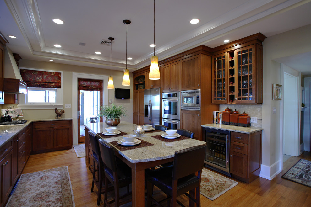 This is an example of a medium sized classic enclosed kitchen in Cincinnati with a submerged sink, shaker cabinets, medium wood cabinets, granite worktops, beige splashback, stainless steel appliances, medium hardwood flooring and an island.