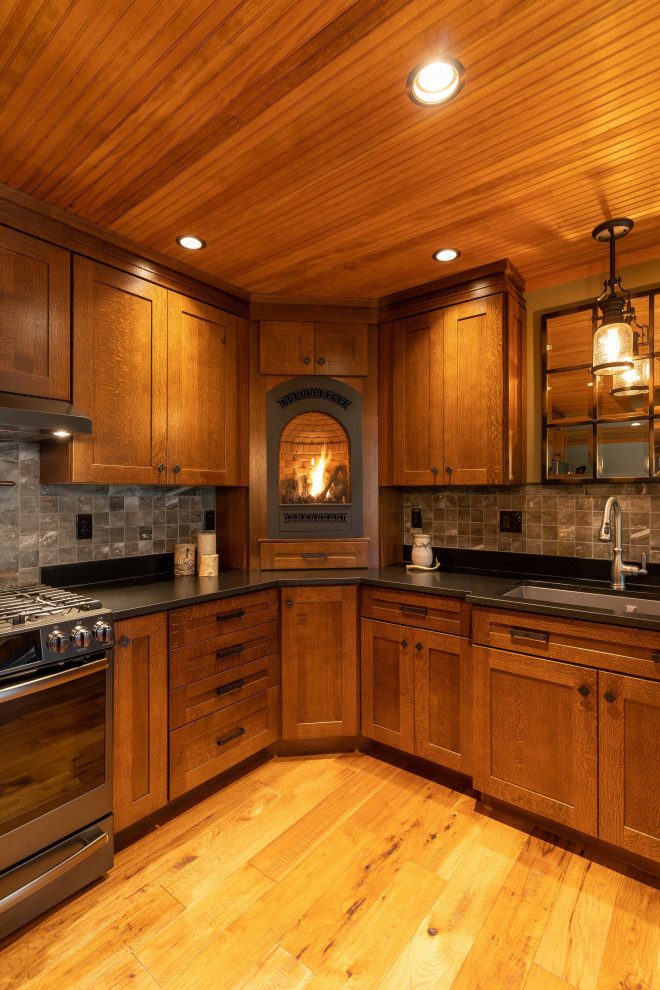 Idéer för ett stort rustikt grå kök, med en undermonterad diskho, luckor med infälld panel, skåp i mellenmörkt trä, grått stänkskydd, rostfria vitvaror, mellanmörkt trägolv, en köksö och brunt golv