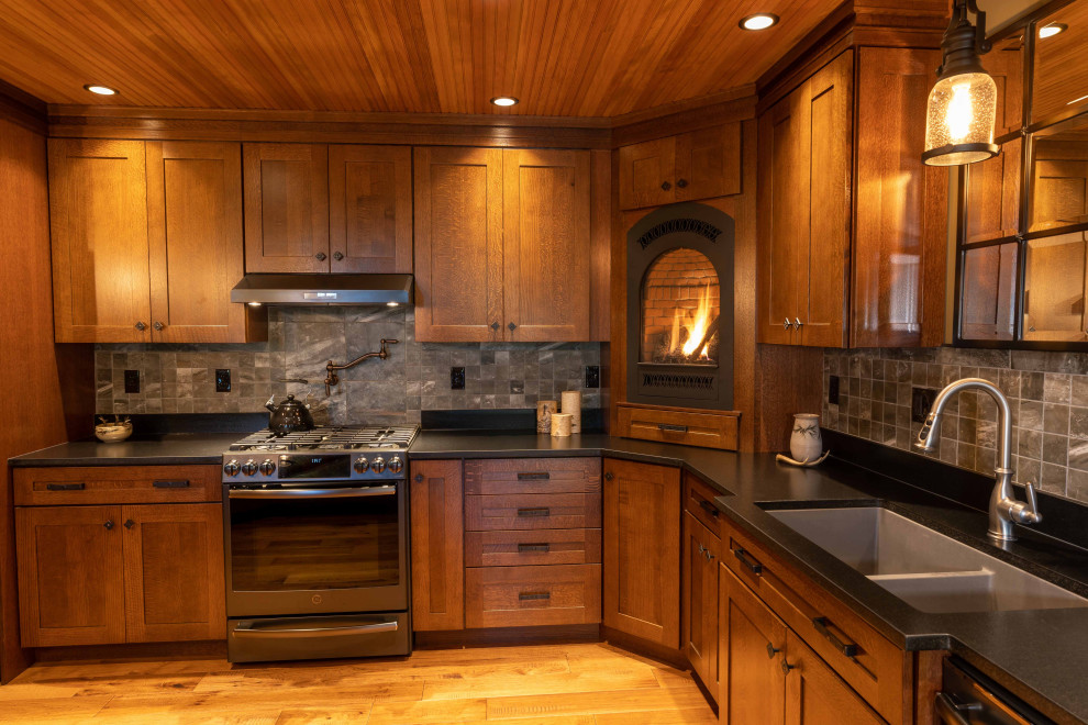 Idéer för stora rustika grått kök, med en undermonterad diskho, luckor med infälld panel, skåp i mellenmörkt trä, grått stänkskydd, rostfria vitvaror, mellanmörkt trägolv, en köksö och brunt golv